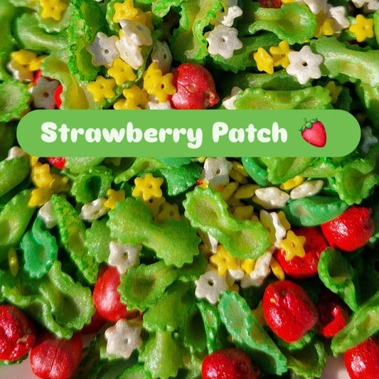 Colorful sensory play mix with green, red, and white pieces labeled 'Strawberry Patch'.